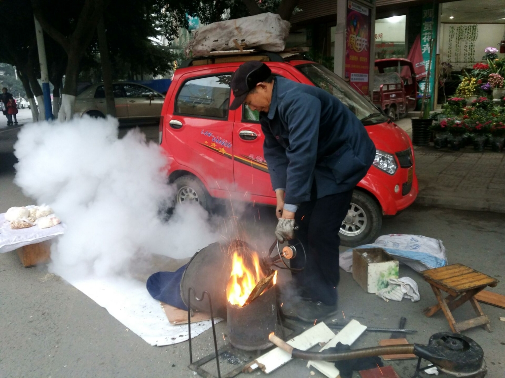 腊月二十七  一位大爷在街上卖爆米花