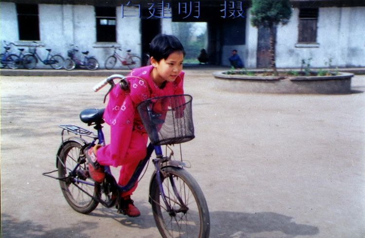 1999.4雷庆瑶9岁就读永胜村小三年级。首次接受媒体采访，无臂骑车（白建明摄）.jpg.jpg